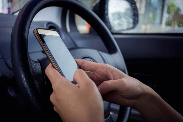 The changes will outlaw almost any use of a handheld phone while driving