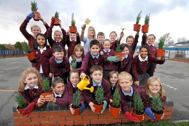 Wood Fold Primary School pupils and eco schools co-ordinator, teacher Rachel Ruddy, with the mini Christmas tree connifers they planted in the Green Fingers gardening club in 2008