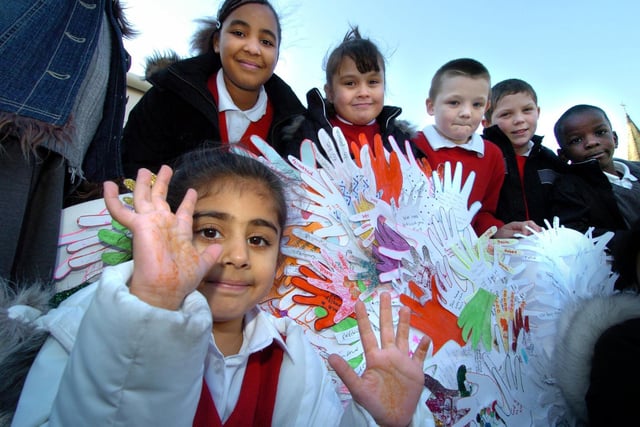 Pupils from St Francis of Assisi School with a dove of peace featuring messages on hand prints at Beeston Co-op.