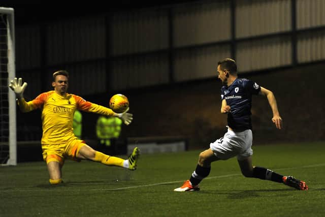 MacLean lifts the ball over Falkirk's Robbie Mutch to score.