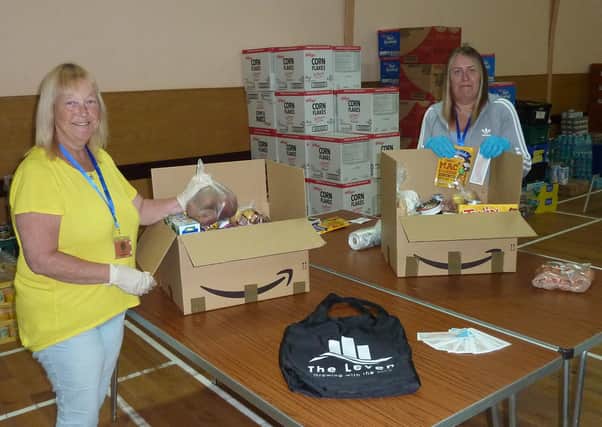 Volunteers pack food parcels with items related to the programme.