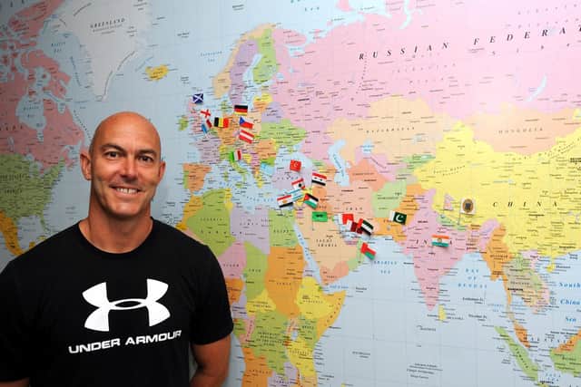 Principal teacher of PE Malcolm Stewart from Kirkcaldy High in front of a world map he used to chart the progress of staff and pupils who took part in a 'World Travel' PE Challenge from May until the end of the school term, using Strava. Pic:  Fife Photo Agency.