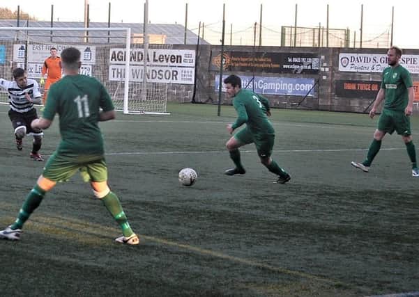Dean McMillan in possession watched by Daniel McNab and Adam Drummond