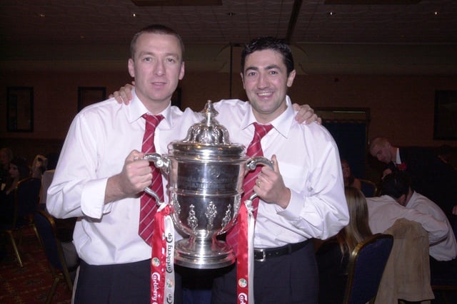 Derry City's 2002 match winner Liam Coyle and defender Peter Hutton, holding the FAI Cup trophy, following their win over Shamrock Rovers.