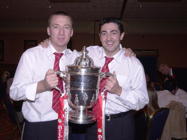 Derry City's 2002 match winner Liam Coyle and defender Peter Hutton, holding the FAI Cup trophy, following their win over Shamrock Rovers.