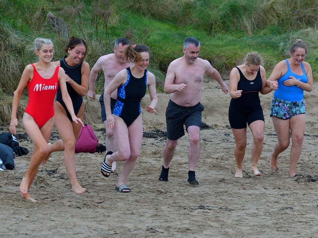 Enthusiastic swimmers run towards Lough Swill during the annual Christmas Day swim at Ludden beach, Buncrana. Photo: George Sweeney. DER2151GS – 015