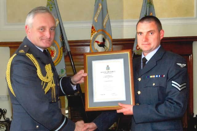 Brian (right) receiving an accommodation from his time in the RAF.