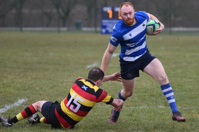Howe of Fife centre Greg Frearson fending off a tackle for the first of his five tries against Greenock Wanderers during Saturday's 109-3 home win (Pic: Chris Reekie)
