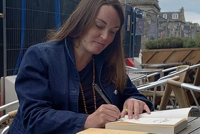 Jemma Neville, author of Constitution Street adds an inscription to the book being placed in the 2022 time capsule