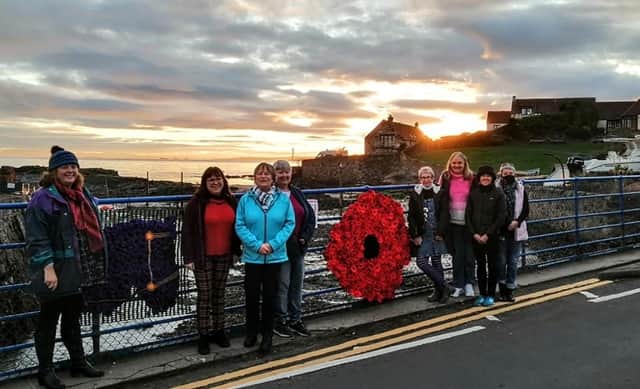 The ladies attach a knitted wreath to the bridge in Lower Largo by the Crusoe Hotel