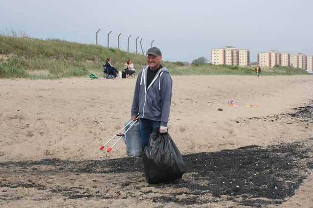 A Seafield Environmental Group volunteer litter picking on Seafield Beach.