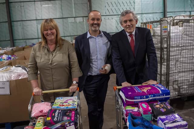 From left, Pauline Buchan of The Cottage Family Centre; John Boumphrey of Amazon and former Prime Minister Gordon Brown at the distribution warehouse in Lochgelly.  Pic: Gareth Easton.