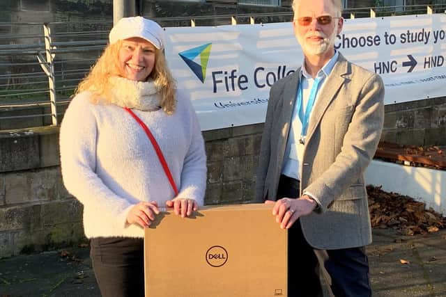 John Wincott, Environmental Services Coordinator at Fife College, presents Climate Change Scholarship winner, Alison Major, with her laptop outside the College's Kirkcaldy Campus.