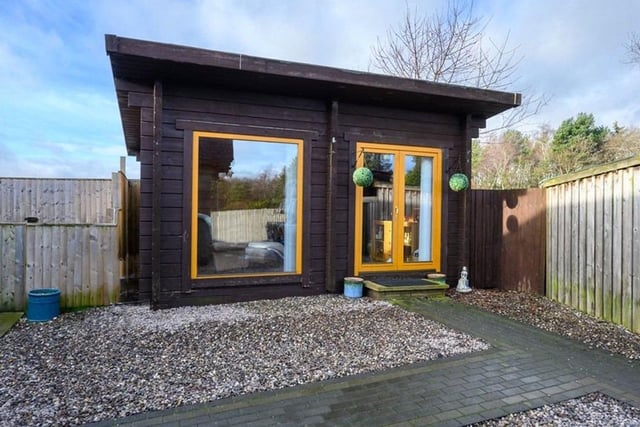 A timber built log cabin which can have many uses sits to the rear of the property.