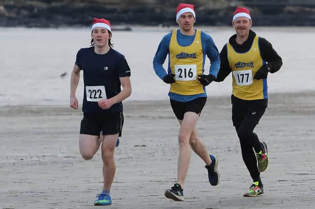 East Fife Triathlon Club's Thomas Robertson winning Anster Haddies' 5k Santa's Sleigh of Fire beach run on Sunday at St Andrews, followed by the host club's Ross Young and Tom Rainey