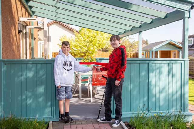 Cupar brothers Elliot and Aaron Berghuis mark the re-opening of TCCL Lodge and its new gazebo funded by the Meikle Trust.  Pic: Caroline Trotter Photography.