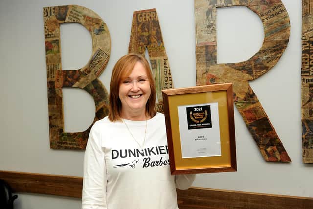Dunnikier Barbers owner Evelyn Duncan with the award  for best barbers in Scotland. Pic: Fife Photo Agency