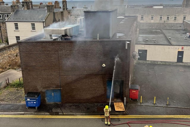 Firefighters tackle the blaze at the rear of the disused shop.