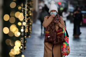 A member of the public wearing a face covering shopping on Buchanan Street in Glasgow, Scotland where severe lockdown restrictions have been announced for December and January with most of the country moving into the highest level of lockdown from Boxing Day.