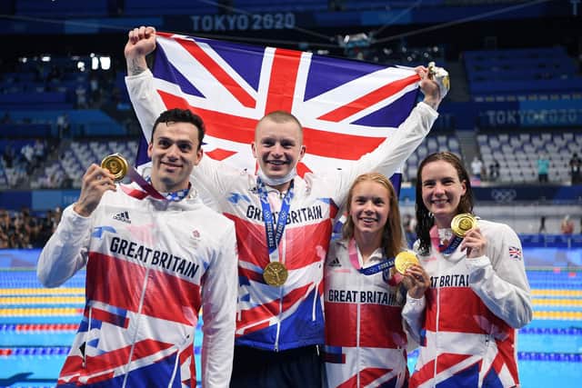 Gold medallists Britain's James Guy, Britain's Adam Peaty, and Britain's Anna Hopkin and Britain's Kathleen Dawson pose with their medals at the side of the pool after the final of the mixed 4x100m medley relay swimming event during the Tokyo 2020 Olympic Games at the Tokyo Aquatics Centre in Tokyo on July 31, 2021. (Photo by Jonathan Nackstrand/Getty Images)