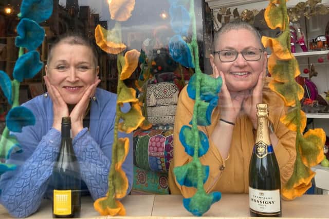 Elizabeth Adams and Alexa Stewart in the shop window after the £5000 fundraising head shave