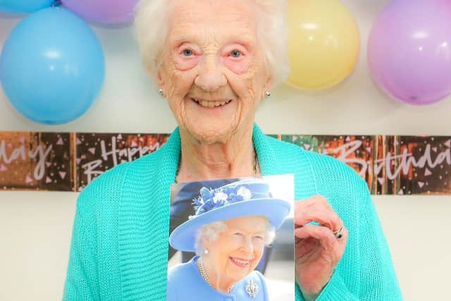 Mrs Catherine Drummond on her 100th birthday with a photo of the Queen