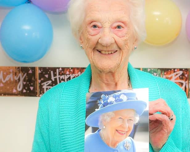 Mrs Catherine Drummond on her 100th birthday with a photo of the Queen
