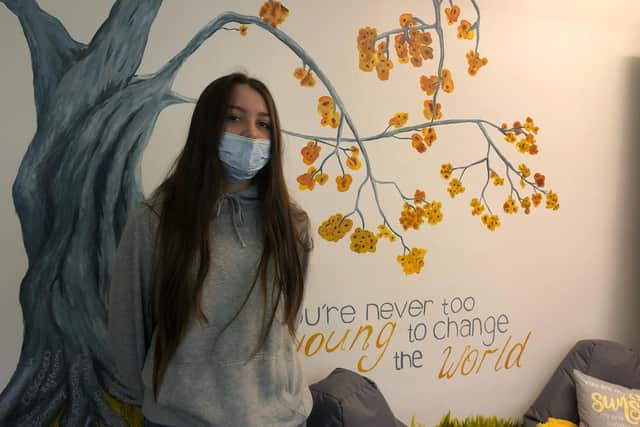 Tamarah Howsego next to the hand painted tree in the wellbeing room.