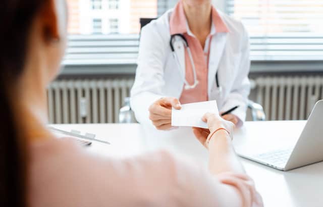Stock image of a GP handing over a prescription to a patient