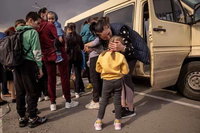 A woman kisses a girl after  arriving at an evacuation point for people fleeing Mariupol (Photo by Chris McGrath/Getty Images)