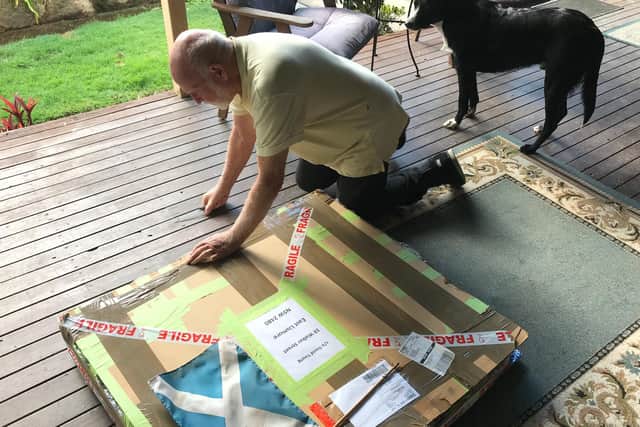 David opening the box that the painting was shipped in after being lost for decades.