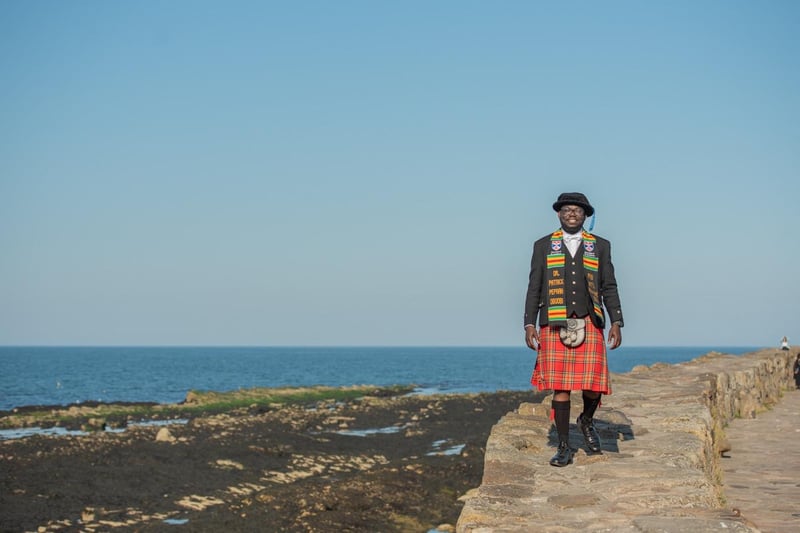 Patrick Obuobi from Ghana dressed in a kilt especially made for his graduation day at the University of St Andrews, Tuesday 13 June 2023.  Patrick graduated with a PhD in International Relations and wore a scarf made in Ghana for the day.