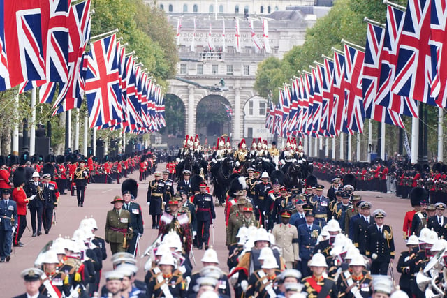 The State Gun Carriage carries the coffin of Queen Elizabeth II, draped in the Royal Standard with the Imperial State Crown and the Sovereign's orb and sceptre, in the Ceremonial Procession following her State Funeral at Westminster Abbey, London. Picture date: Monday September 19, 2022.