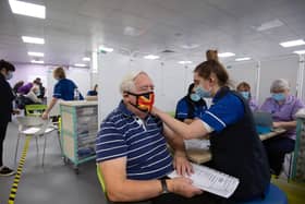 Robert Williams, 84, receives a vaccine at one of the seven mass vaccination centres already opened in England.