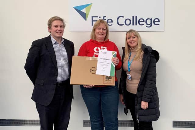 John Lewthwaite, Director of Estates at Fife College (right), and Lyn Gold, Scholarship and Alumni Engagement Lead at Fife College (left), present Climate Change Scholarship winner, Josie Chaplin, with her laptop at the College's Kirkcaldy Campus.