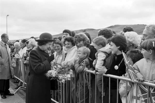 The Queen sniffs some flowers given to her when she officially opened the new ethylene plant at Mossmorran in June 1986.