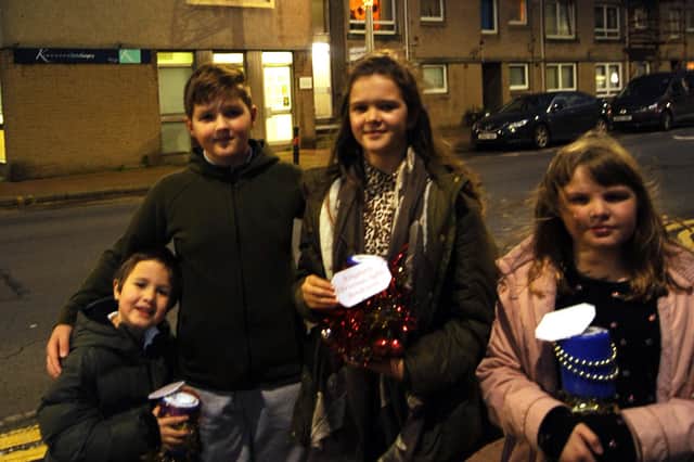 Luke Gregson, Ryan McIlreavie, Erin McIlreavie and Myla Gregson with their Christmas themed collection tins  at the light switch-on in Kinghorn. Pic: Fife Photo Agency