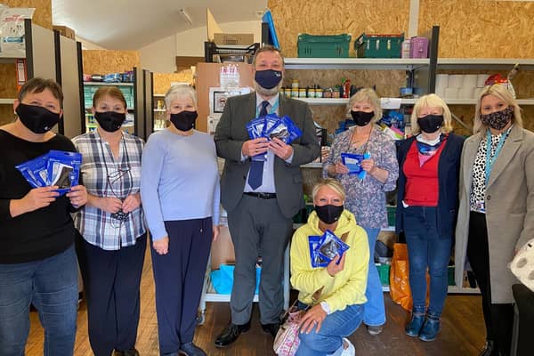 Colleen Wilkie (kneeling) and Fife College lecturers, Natalie Kerr (far right) and Ciaran Faherty (centre), are pictured presenting facemasks to staff at the Kirkcaldy Foodbank Viewforth Distribution Point.