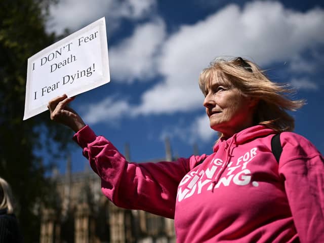 A disability campaigner from "Dignity in Dying" holds a placard as she demonstrates outside  Westminster (Pic: Ben Stansall/AFP via Getty Images)