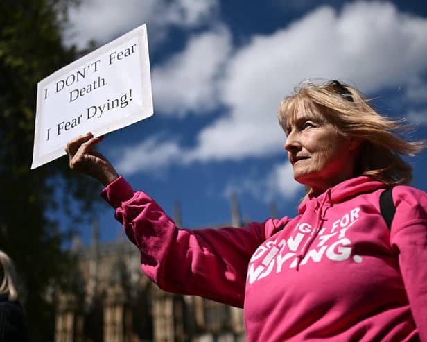 A disability campaigner from "Dignity in Dying" holds a placard as she demonstrates outside  Westminster (Pic: Ben Stansall/AFP via Getty Images)