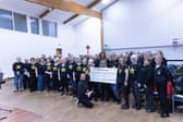 Glenrothes Rock Choir and their leader Rachel Leitch present a cheque to The Cottage Family Centre.