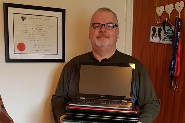 Mike with some of the refurbished laptops.