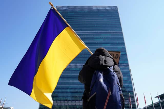 A protester with a Ukranian flag demonstrates outside the United Nations headquarters in New York  (Photo by TIMOTHY A. CLARY/AFP via Getty Images)