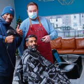 Amir Salim in the barbers chair with Marvin Andrews and barber Jamie Thorburn at the opening of Square One.