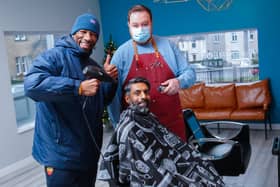 Amir Salim in the barbers chair with Marvin Andrews and barber Jamie Thorburn at the opening of Square One.