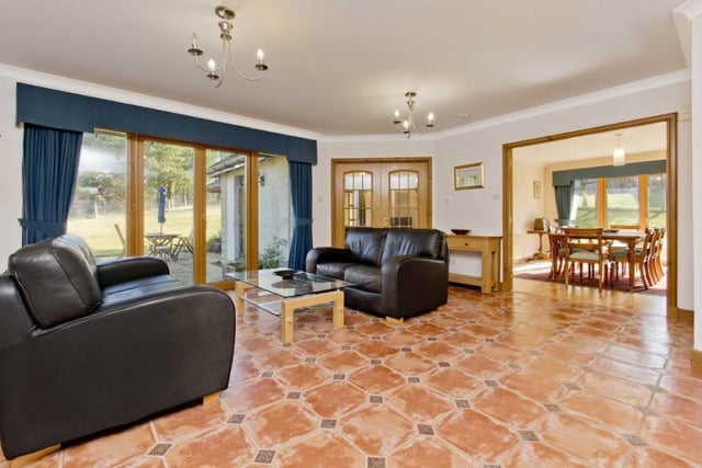 The family room has terracotta-toned floor tiling, continuing from the vestibule, and garden access.