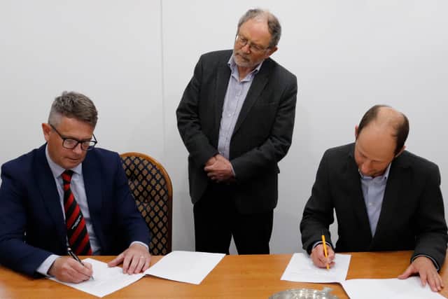 Tayport FC committee member, Dave Aitken, pictured left, Signpost International’s CEO, Jamie Morrison, pictured on the right, and Tay Bridgehead
Councillor, Tim Brett met together as the charity partnership agreement was signed.