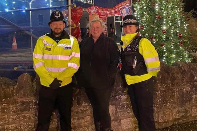 Two Police officers and Gemma Lennane, the owner of Cakefield Tearooms, who brought the Pleasley Christmas Lights Group volunteers together. They are pictured enjoying the evening's festivities by the decorated Christmas tree bathed in lights.