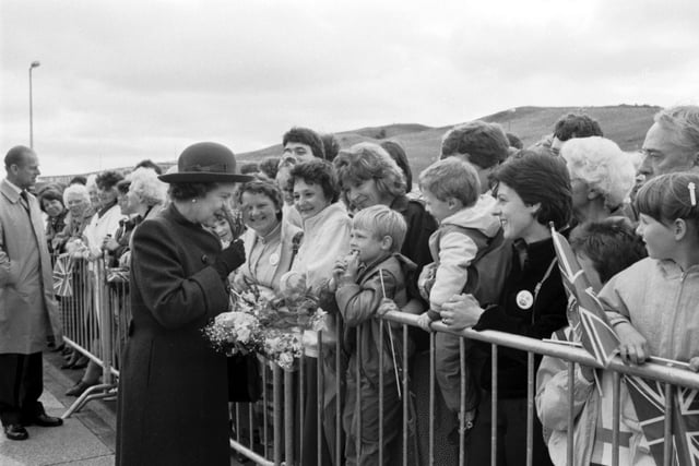 Queen Elizabeth II sniffs some flowers given to her when she officially opened the new ethylene plant at Mossmorran in June 1986.