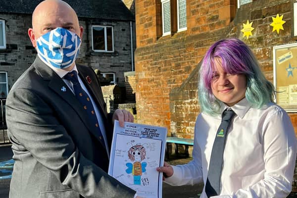 Neale Hanvey MP is pictured with competition winner Sadie Williams with her winning poster design.